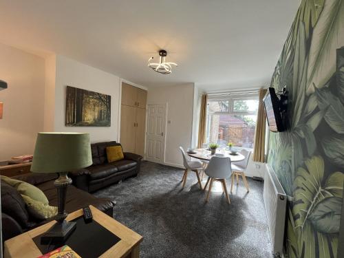 a living room with a couch and a table at Modernised central Wigan townhouse sleeps up to 6 in Wigan