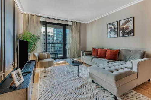 a living room with a couch and a tv at MySquare South Quay 02 Bed Water Front Apartments in Canary Wharf in London