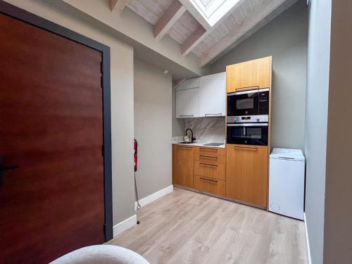 a kitchen with wooden cabinets and a door at La Quinta del Sordo in Luarca