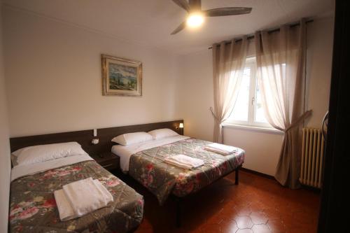 een slaapkamer met twee bedden en een raam bij R&B Casa Wanda since 1999 in Riva del Garda