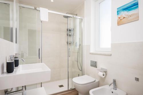 a bathroom with a toilet sink and a shower at Keys of Sicily - Residence "Sabbia" sul mare in Marina di Modica
