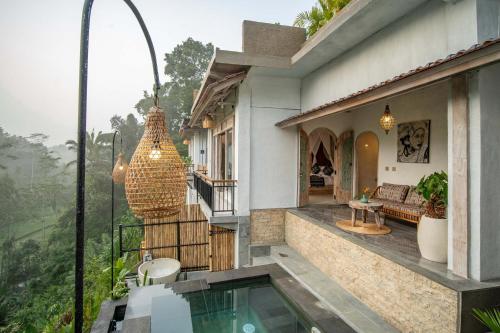 a house with a balcony with a swimming pool at Legong Sebatu Villa in Ubud