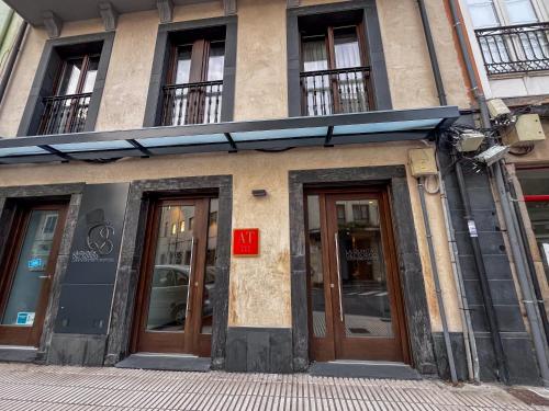 a building with doors and windows on a street at La Quinta del Sordo in Luarca