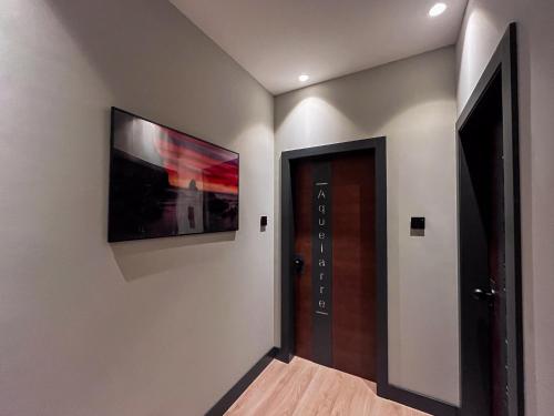 a hallway with a door and a television on the wall at La Quinta del Sordo in Luarca
