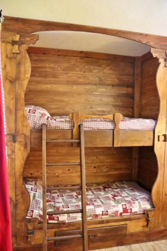 two bunk beds in a room with wooden walls at Chèvres à Cheval - Apartment in Aosta