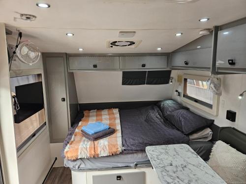 a small bed in the back of an rv at Kimberley Caravan Stay in Kununurra