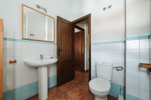 a bathroom with a toilet and a sink at Casa Higuera de la Sierra in Higuera de la Sierra