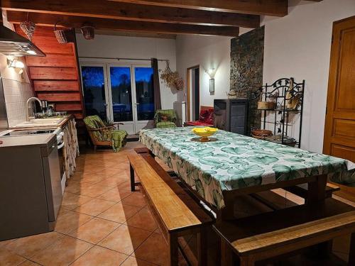 a kitchen with a table in the middle of a room at La Ferme - Maison avec terrasse in Mélisey