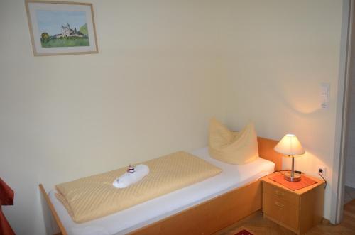 a bed with a mouse and a lamp on a table at Gästehaus im Priesterseminar Salzburg in Salzburg