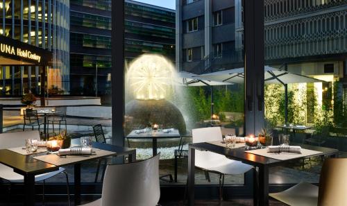 a restaurant with tables and chairs and a fountain at UNA Hotels Century Milano in Milan