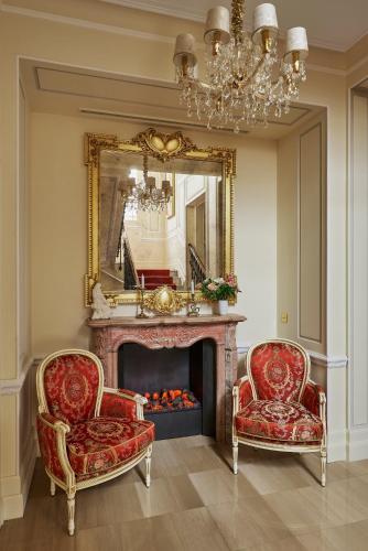 a living room with two chairs and a fireplace at Maison des Barons in Nice