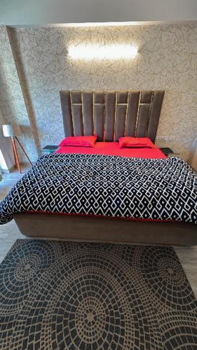 a bedroom with a bed with red pillows on it at Wanderers inn- beautiful hills view in Dehradun