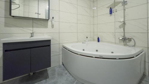 a white bathroom with a sink and a bath tub at Altınova Hotel Sakarya in Serdivan