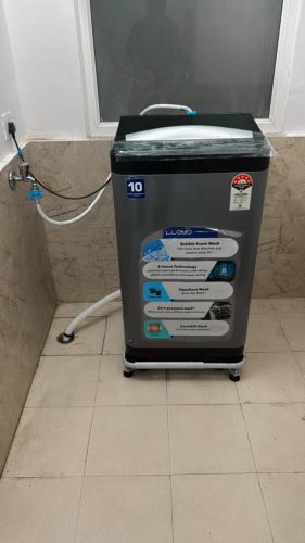 a washing machine sitting on a floor in a bathroom at Wanderers inn- beautiful hills view in Dehradun