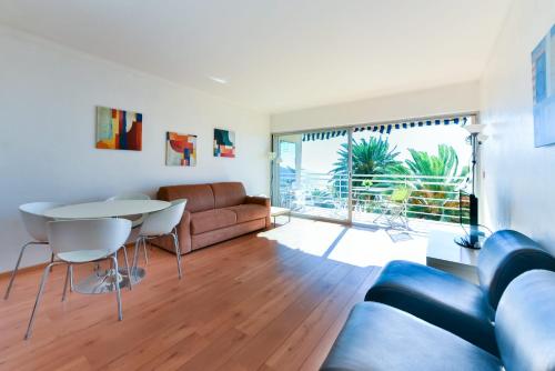 un salon avec un canapé et une table dans l'établissement LA BELLE VUE mer avec joli balcon et parking, à côté des plages et du centre-ville, à Cannes