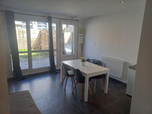 une salle à manger avec une table et des chaises blanches dans l'établissement Appt N1 Motte T2 Calme et Agréable, à Tourcoing