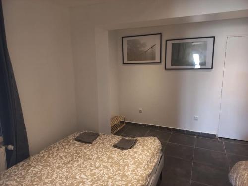 une chambre avec un lit et deux tableaux au mur dans l'établissement Appt N1 Motte T2 Calme et Agréable, à Tourcoing
