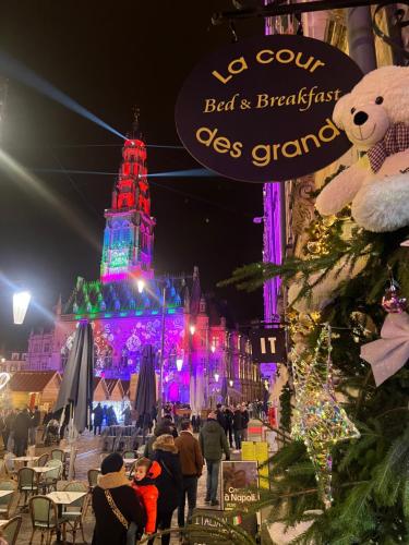 a christmas market in front of a building with christmas lights at La cour des grands in Arras