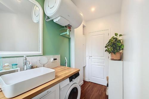 une salle de bain avec un lavabo et une machine à laver dans l'établissement A cosy haven in Versailles charm and comfort, à Versailles
