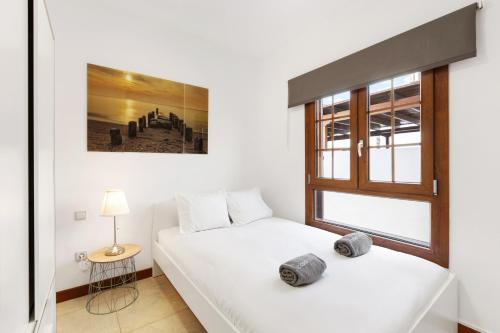 two beds in a room with a window at Aquavilla in Costa Teguise