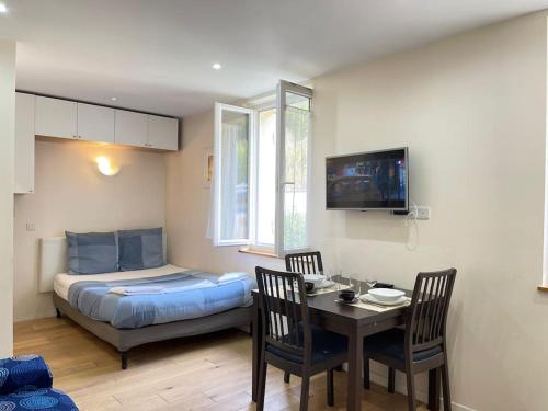 a bedroom with a bed and a table and chairs at Appart Jouy N4 proche HEC Rer C in Jouy-en-Josas