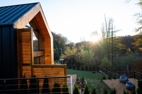 a small cabin in a garden with the sun shining at Golden Wood in Sovata