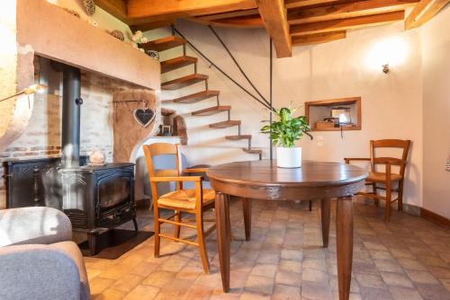 - une salle à manger avec une table et un poêle à bois dans l'établissement La Petite Tour du Château de Salornay, à Hurigny