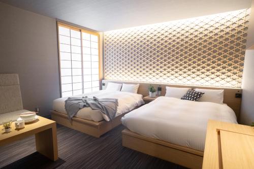a bedroom with two beds and a window at ORI Kyoto in Kyoto