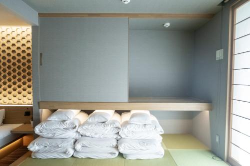 a room with a bunch of white pillows at ORI Kyoto in Kyoto