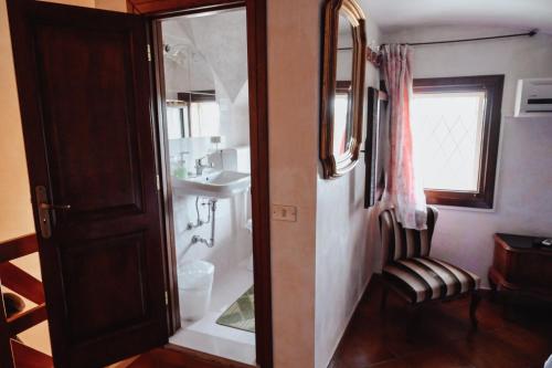 a bathroom with a shower with a chair and a mirror at Villa Delle Palme in Trepuzzi