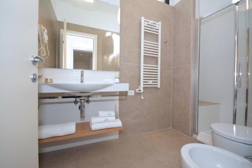 a bathroom with a sink and a toilet and a mirror at Hotel Miramare in Otranto