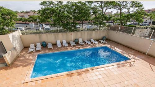 - une piscine avec des chaises longues dans l'établissement PALME D or N 37 - 2P6C, au Cap d'Agde