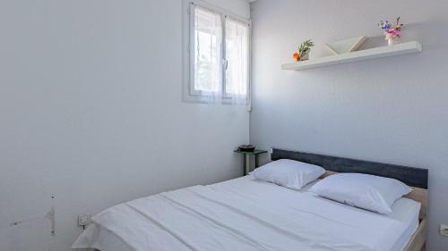 - une chambre blanche avec un lit et deux oreillers dans l'établissement PALME D or N 37 - 2P6C, au Cap d'Agde
