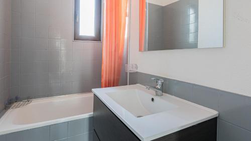 La salle de bains est pourvue d'un rideau de douche orange et d'un lavabo. dans l'établissement PALME D or N 37 - 2P6C, au Cap d'Agde