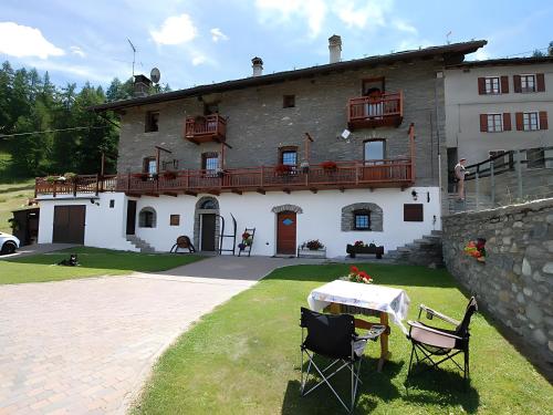 a house with a table and chairs in front of it at Maison Cerise Pila in Gressan