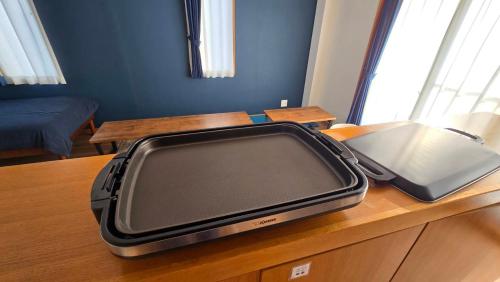 a suitcase sitting on top of a wooden table at EarthVeloビル一棟貸しでフルリノベ済み各階に風呂トイレありで好立地でコスパ最高をめざしている宿です in Tokushima