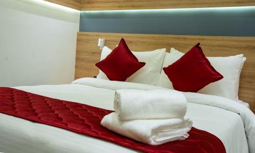 a bedroom with a large bed with red and white pillows at AJ Palace in Alleppey