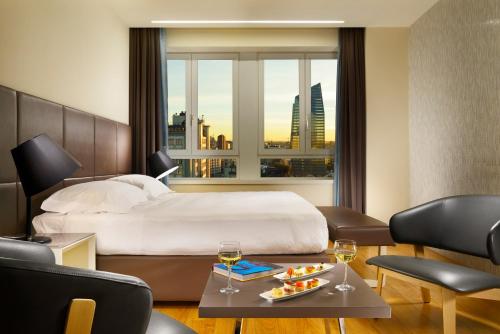 um quarto de hotel com uma cama e uma janela em UNAHOTELS Century Milano em Milão