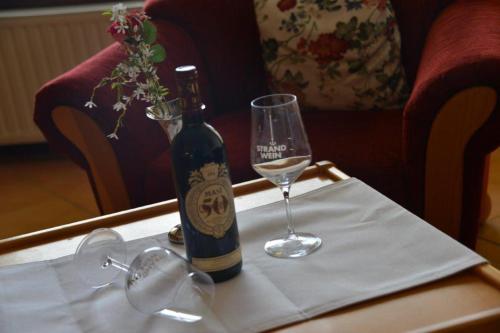 eine Flasche Wein und ein Glas auf dem Tisch in der Unterkunft Haus Christianenhöhe App 40 in Westerland