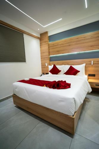 a bedroom with a large bed with red pillows at AJ Palace in Alleppey