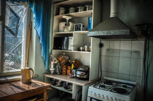 a small kitchen with a stove and a sink at Guesthouse Kishimzhan in Talas