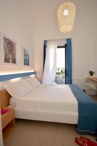 a bedroom with a large white bed and a window at Hotel Miramare in Otranto