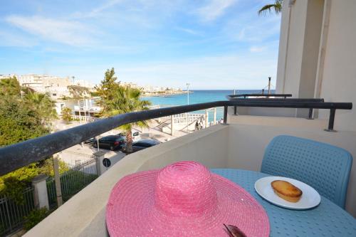 a pink hat sitting on a table on a balcony at Hotel Miramare in Otranto