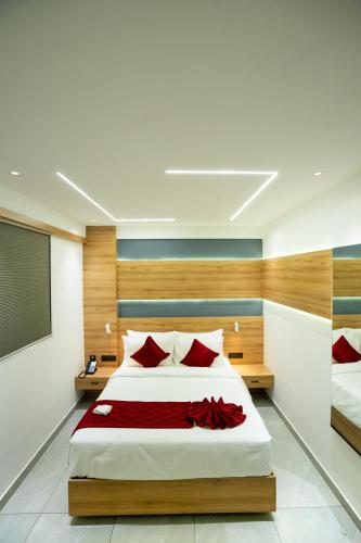 a bedroom with a large bed with red pillows at AJ Palace in Alleppey