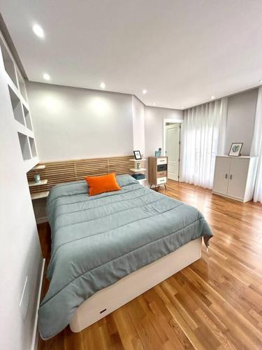 a bedroom with a large bed with an orange pillow at La Catedral - Más que apartamentos lujo in Murcia