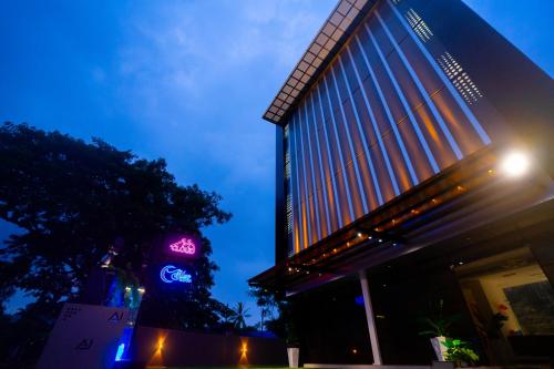 a building with a neon sign in front of it at AJ Palace in Alleppey