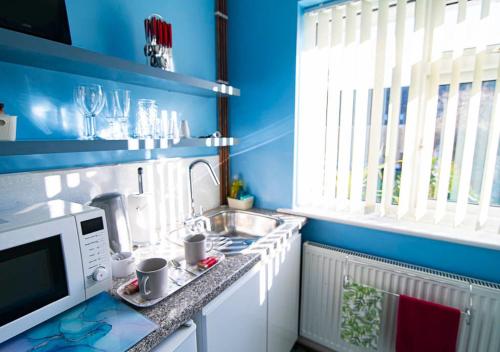 a kitchen with a sink and a microwave at Broadstairs, Bays & Golf - Sleeps 2 in Broadstairs