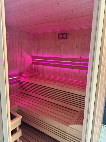 a sauna with pink lighting in a pink room at Hotel *** NAT Kołobrzeg in Kołobrzeg