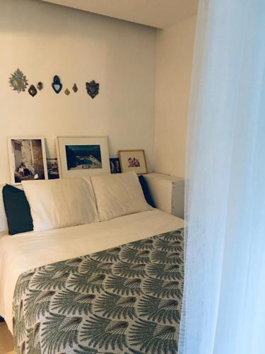 une chambre avec un lit et des tableaux au mur dans l'établissement Les Terrasses D'Aix, à Aix-en-Provence