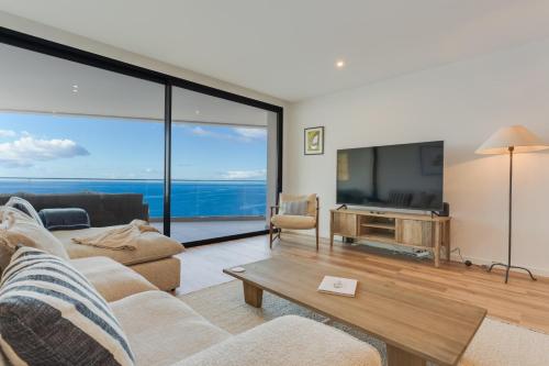 a living room with a large screen tv and a couch at Atlantic Heights Varandas do Atlântico by Holiday Rental Madeira in Câmara de Lobos